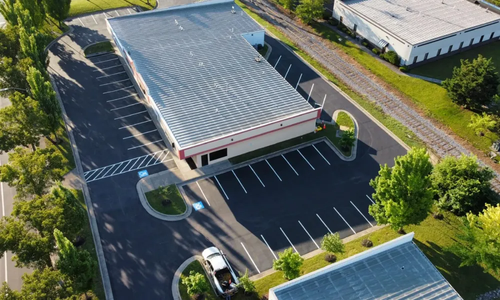 new-asphalt-paving-in-parking-lot-with-green-grass-areas